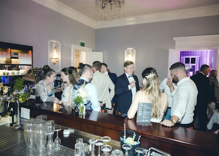 Hochzeitsgäste an der Bar während der Feier im Eventschloss Schönfeld