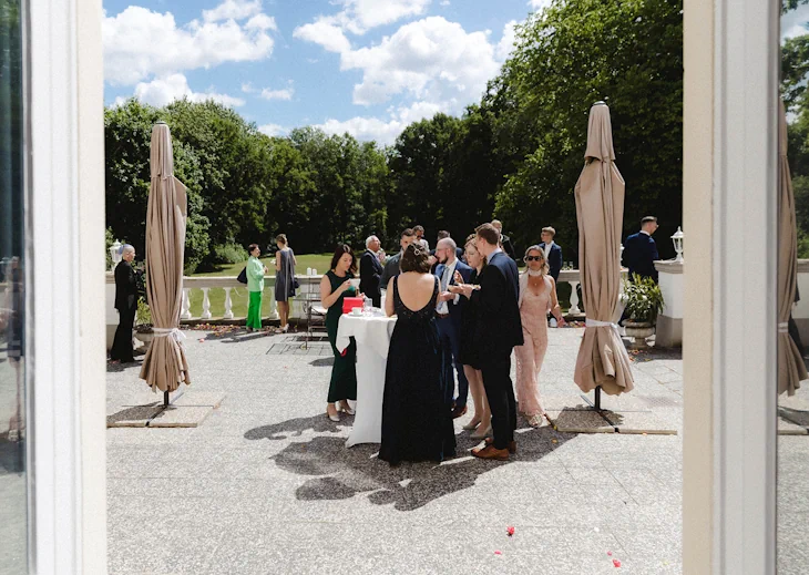 Hochzeitsgäste beim Sektempfang auf der Schlossterrasse des Eventschloss Schönfeld