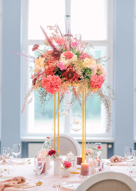 Hochzeitstafel mit großem Blumenarrangement im Festsaal des Eventschloss Schönfeld