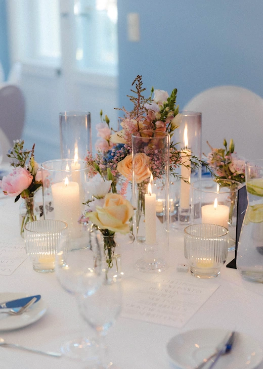 Hochzeitstisch mit pastellfarbenen Rosen und Kerzen im Eventschloss Schönfeld