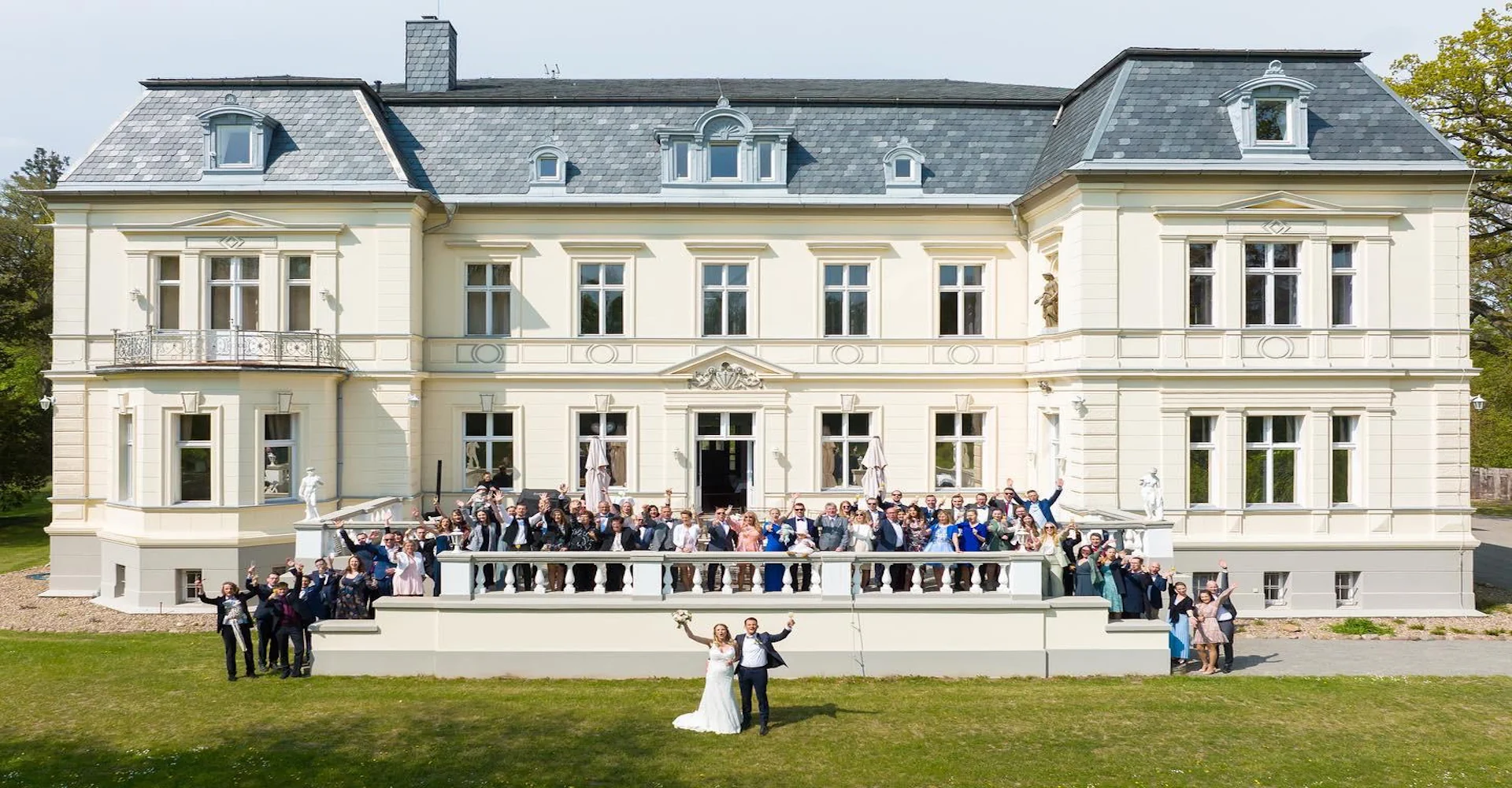Brautpaar mit Hochzeitsgästen beim Hochzeitswochenende im Schloss Schönfeld